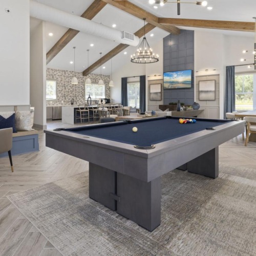 a large room with a pool table and chairs