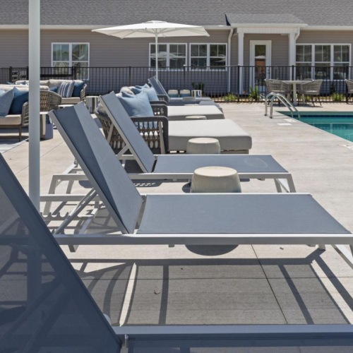a swimming pool with lounge chairs around it